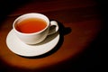A cup of refreshing black tea, warm soft light, dark wood background. Royalty Free Stock Photo