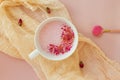 Cup of rose cardamom ayuverdic drink on pink background.