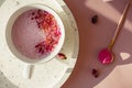 Cup of rose cardamom ayuverdic drink on pink background.