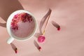 Cup of rose cardamom ayuverdic drink on pink background.