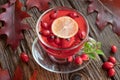 A cup of rosehip tea with rosehips and autumn leaves Royalty Free Stock Photo