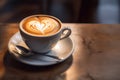 Cup on a saucer with cappuccino with a heart design on the table Royalty Free Stock Photo