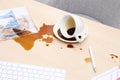 Cup with saucer and coffee spill on office desk Royalty Free Stock Photo