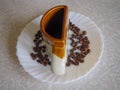 The Cup is shaped like a half on a white plate and coffee beans are around Royalty Free Stock Photo