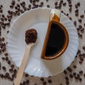 The Cup is shaped like a half on a white plate and coffee beans are scattered around Royalty Free Stock Photo