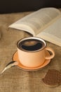 A cup of smiley coffee with a book