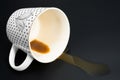 A cup of spilled coffee photographed against a dark background Royalty Free Stock Photo