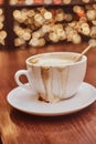 Cup with spilled coffee on the wooden table in a coffee shop, blur background with bokeh effect Royalty Free Stock Photo