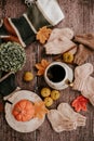 Cup of strong black coffee, autumn leaves and handmade woolen socks on wooden background