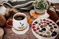 Cup of strong black coffee, autumn leaves and handmade woolen socks on wooden background