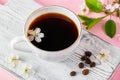 Cup of strong espresso coffee and delicate spring flowers on a pink background. Springtime and good morning concept Royalty Free Stock Photo