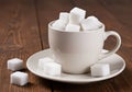 Sweet Sugar Cubes Overflowing a White Coffee Cup on a Wooden Table A Delicious Dessert or Coffee Break Concept Royalty Free Stock Photo