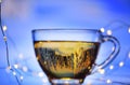 Cup of tea abstract image without focus on a blue winter background with reflection in tea of a winter forest Royalty Free Stock Photo