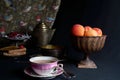 A cup of tea accompanied by fresh apricots, apricot jam and a tray of berries