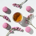 A cup of tea with almond cookies on a white background. Pink pasta and a mug. Flowers in a vase. Macaroons. A Cup of Tea.