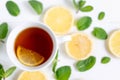 A cup of tea along with mint and lemon. Tea for colds. Natural cures for the disease. Vitamin C. Black tea with lemon on a white