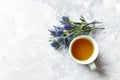 Cup of Tea and Amethyst Sea Holly Flowers on gray background Royalty Free Stock Photo