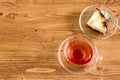 Cup of tea and apple cake on wooden desktop with copy space