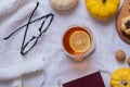 Cup of tea and autumn cozy decor with book, sweater and pumpkins top view. Autumn flat lay Royalty Free Stock Photo