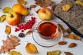 Cup of tea, autumn leaves and fruits on a wooden  background Royalty Free Stock Photo