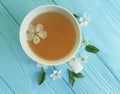 Cup of tea blossoming cherry, aroma composition apricot on blue wooden background