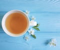 Cup of tea blossoming cherry, aroma blooming natural vintage composition apricot on blue wooden background