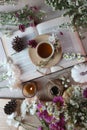 a cup of tea on a book with scattered flowers