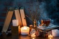 A cup of tea, books, candles, smoke. Mysterious dark still life. Dried flowers. Fairy atmosphere Royalty Free Stock Photo