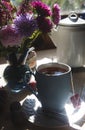 A cup of tea with bouquet of aster flowers, morning tea concept