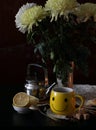 A cup of tea and a bouquet of chrysanthemums