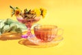 A cup of tea with a bouquet of dandelions on a yellow background, a place for text Royalty Free Stock Photo