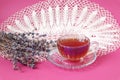 A cup of tea with a bouquet of lavender and a white openwork napkin on a pastel background, close-up, space for text Royalty Free Stock Photo