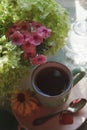 A cup of tea with bouquet of phlox and gortensia flowers, morning tea concept, top view
