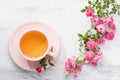 Cup of tea and branch of roses. Royalty Free Stock Photo
