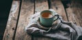 a cup of tea and a bundle of dried leaves on a wooden table