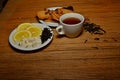 A cup of tea candy lemon cookies on a plate near the tea dumped white black green copy space Royalty Free Stock Photo