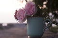 Cup of tea or coffee and pink roses. Empty coffee cup with flowers on sunrise bokeh light background. Happy valentine`s day