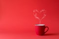 Cup of tea or coffee with steam in one heart shape on red background. Valentine`s day celebration or love concept. Copy space