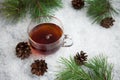 Cup of tea with cones on a snow backgroud