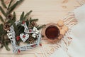 Cup of tea with cookies asterisks with a Christmas wreath heart of winter berries and a white blanket