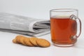 A cup of tea with cookies and a morning newspaper on a white background. Royalty Free Stock Photo
