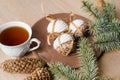 A cup of hot tea with Christmas gingerbread, a branch of a spruce tree on a wooden background Royalty Free Stock Photo