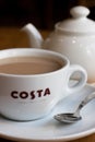 Cup of tea in Costa Coffee cup with teapot in background