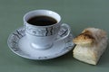 Cup of tea on a dish and a puff pastry Royalty Free Stock Photo