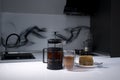 cup of tea in a double-botoom glass, french-press teapot and piece of cake on white table in gray kitchen