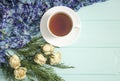 Cup of tea with dried roses and branches of juniper