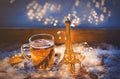 Cup of tea and Eiffel tower toy on snow and fairy lights