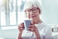 Elegant beautiful retired woman holding blue cup with hot tea