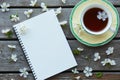 A cup of tea and an empty notebook covered with cherry flowers. Blank space where you can put your text. Royalty Free Stock Photo