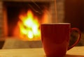Cup of tea on fireplace bokeh background. Royalty Free Stock Photo